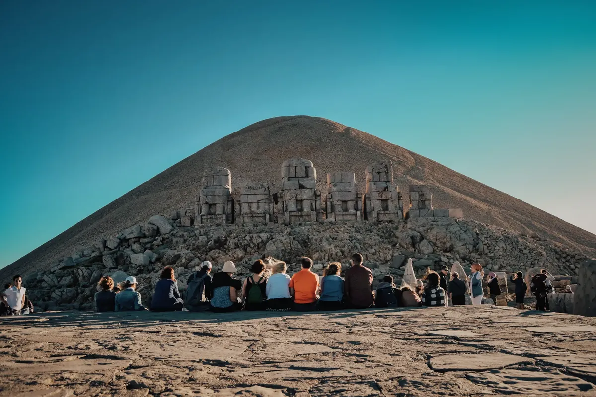 Visitors explore the ancient stone statues at Mount Nemrut, a UNESCO World Heritage Site in Turkey.